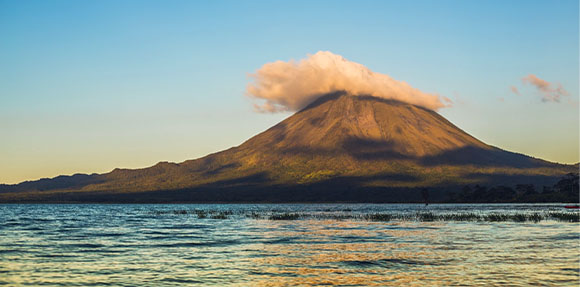 Una montaña que se eleva sobre una masa de agua.
