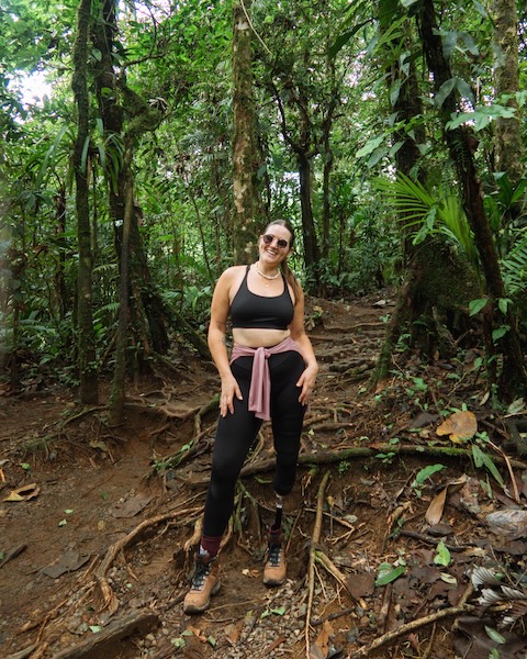 Mujer de excursión en la selva sonriendo