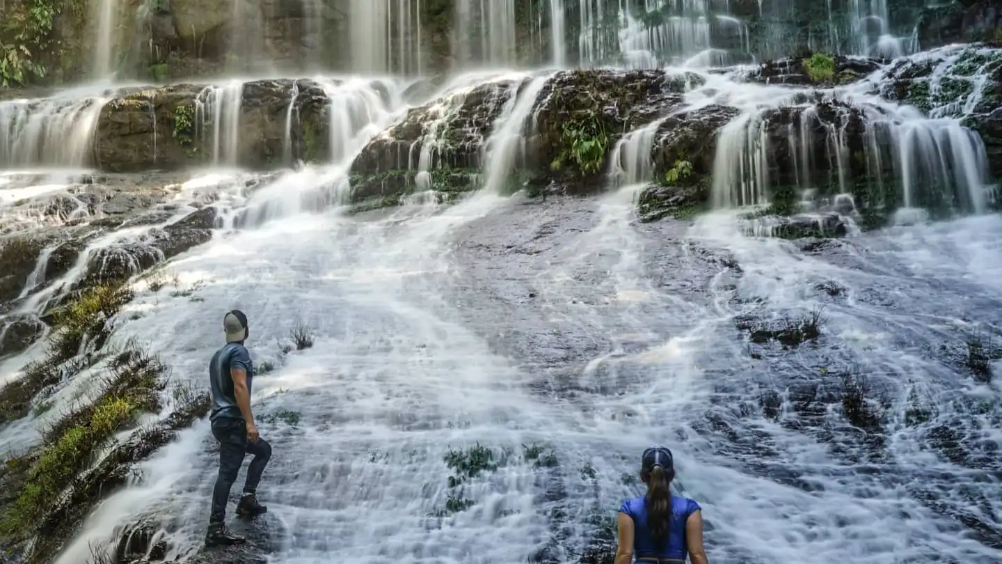 Dos personas frente a una cascada