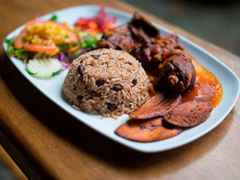 Arroz y frijoles con pollo y ensalada.