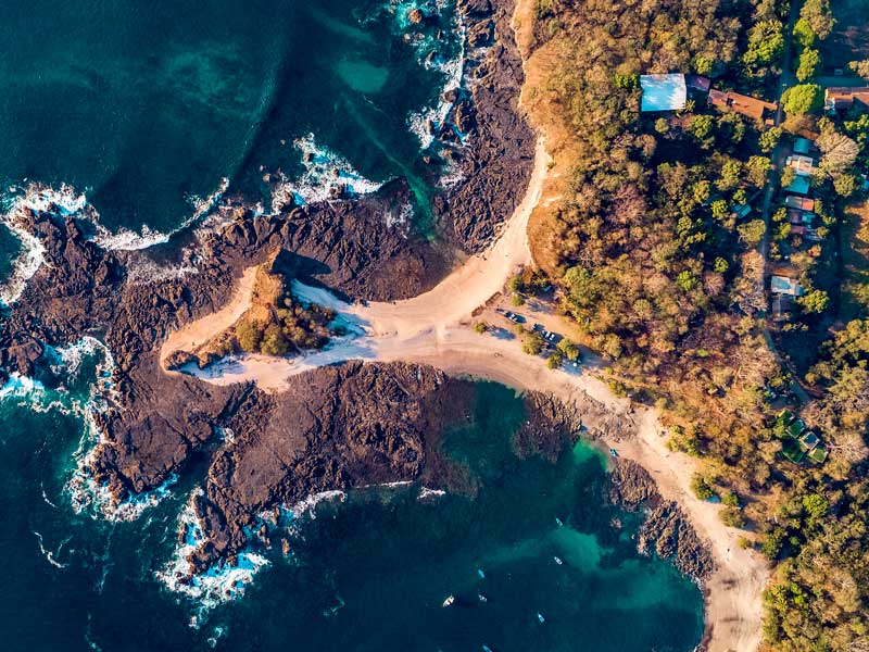 Vista aérea de una playa de arena y el océano.