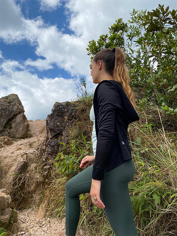 Una mujer con un top negro y leggings verdes