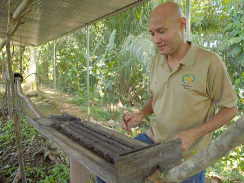 Un hombre de pie junto a una caja de madera.
