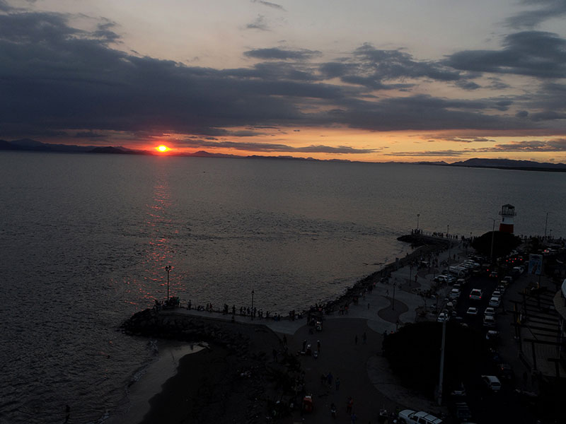 Una gran masa de agua con una puesta de sol de fondo.