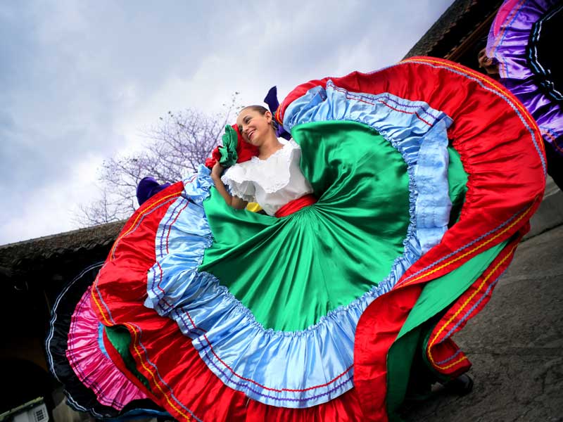 Una mujer con un vestido de colores bailando.