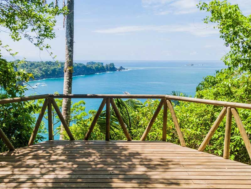 Una terraza de madera con vistas al océano.