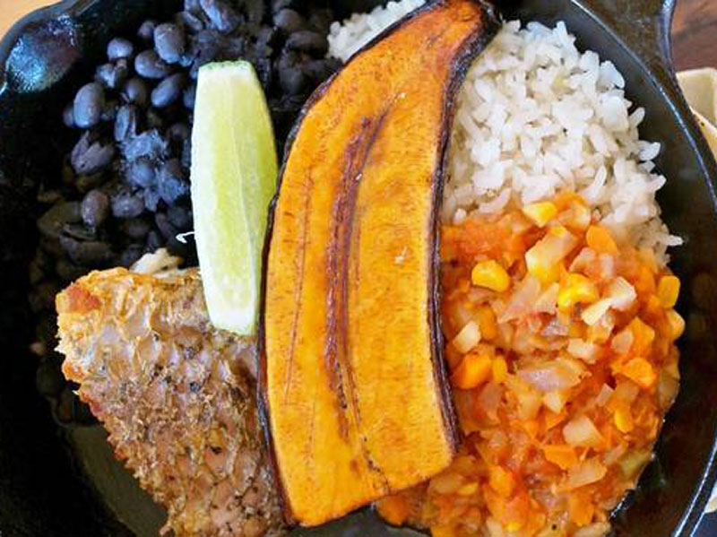 Un plato de comida con arroz, judías y carne.