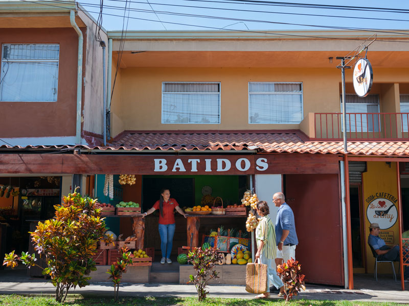 Un par de personas que están de pie delante de una tienda.