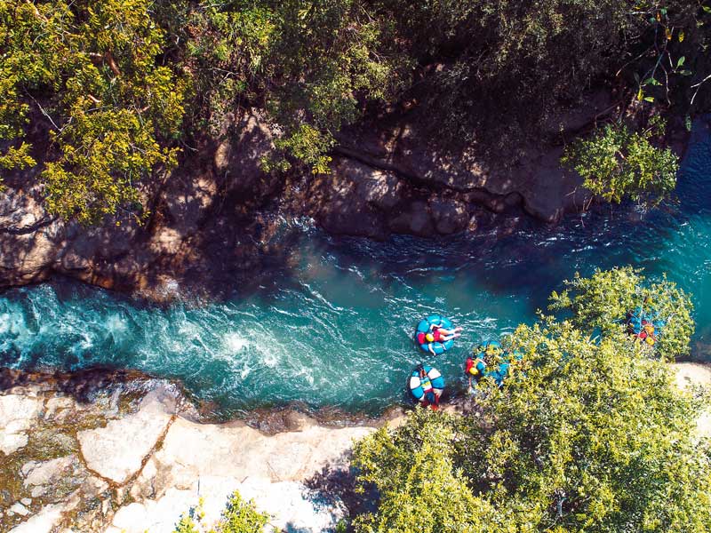 Un grupo de personas en balsas remando río abajo.