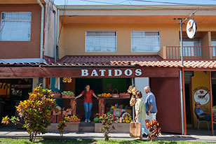 Un par de personas paradas fuera de una tienda.