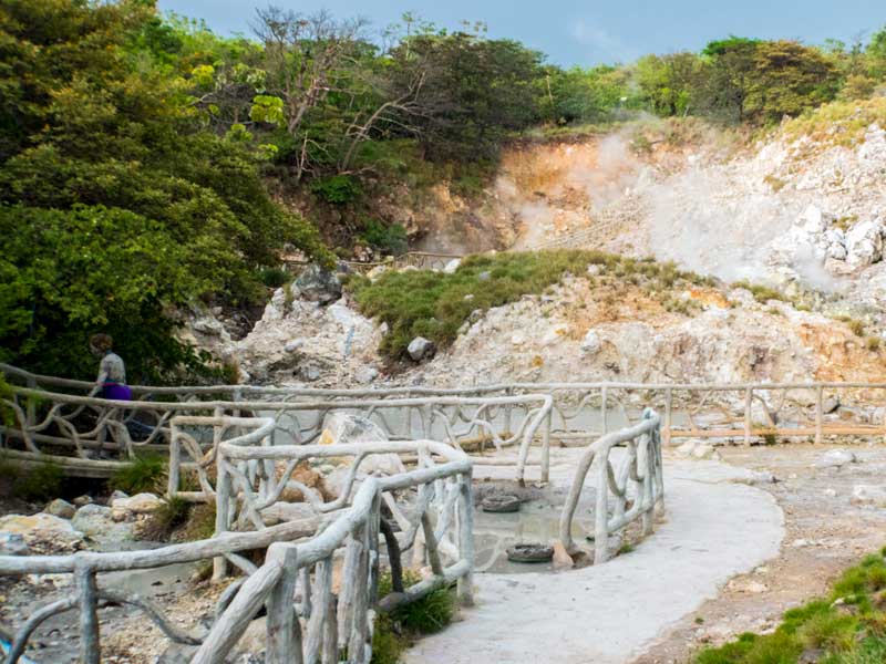 Un hombre camina por un puente de madera sobre un río.