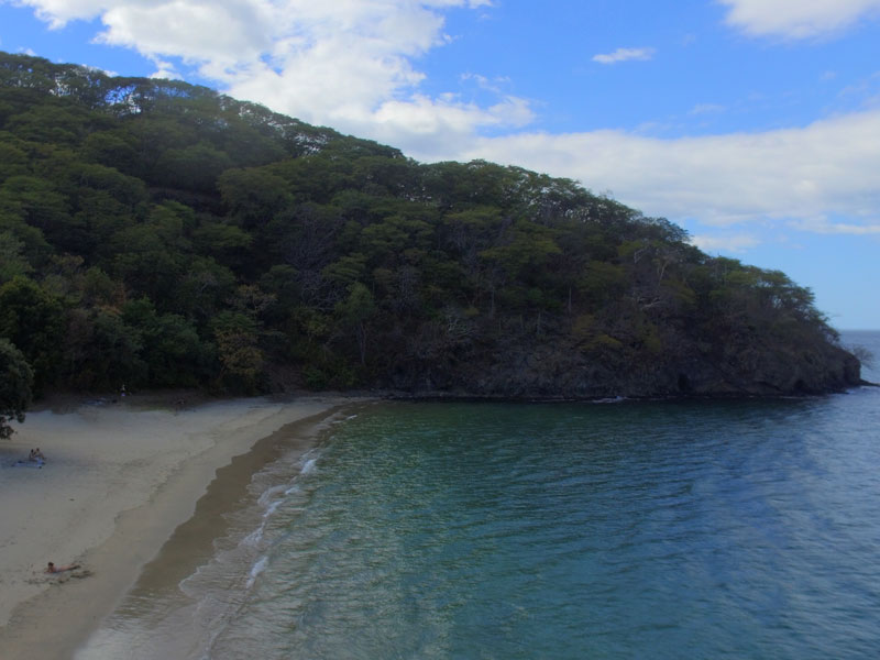 Vista de una playa con una montaña al fondo.