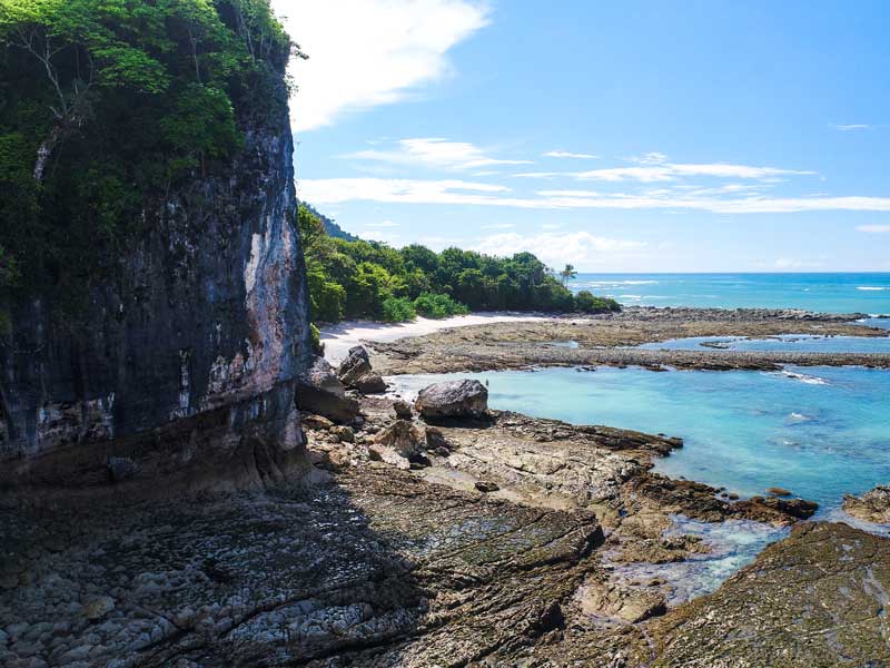 Vista de una playa rocosa con agua azul clara