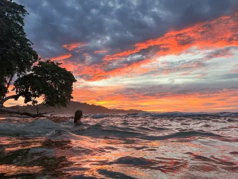 una persona en el océano al atardecer