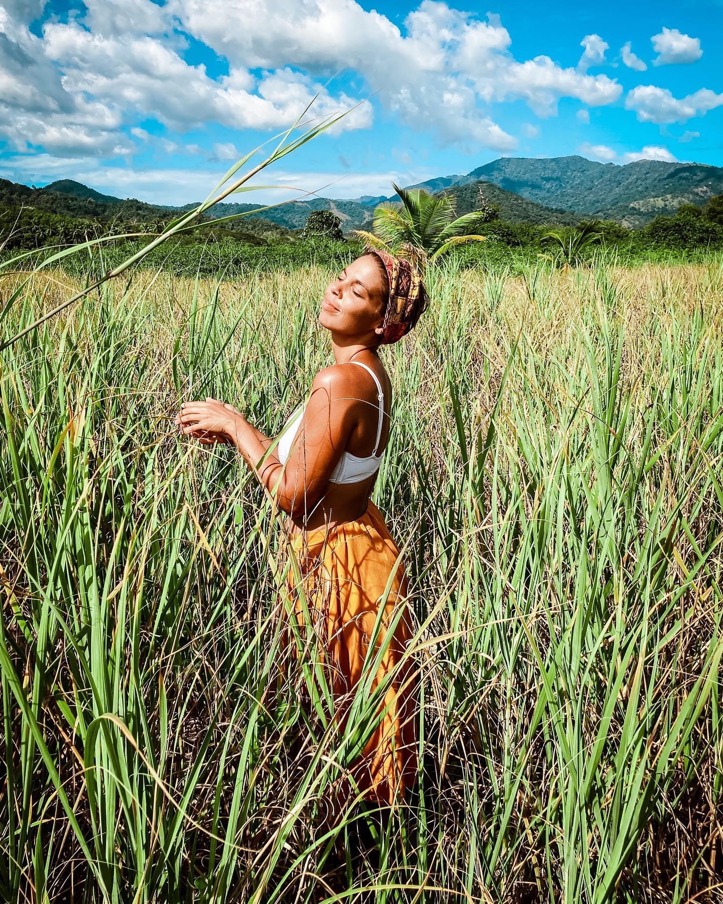 Una mujer de pie en un campo de hierba alta