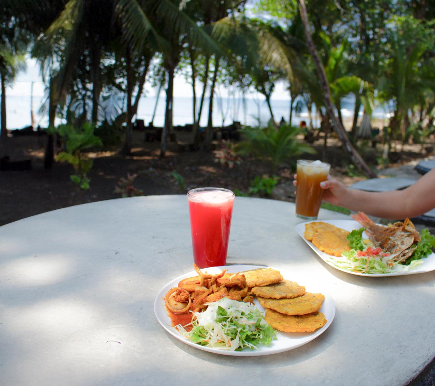 dos platos en una mesa al aire libre con vistas a la playa