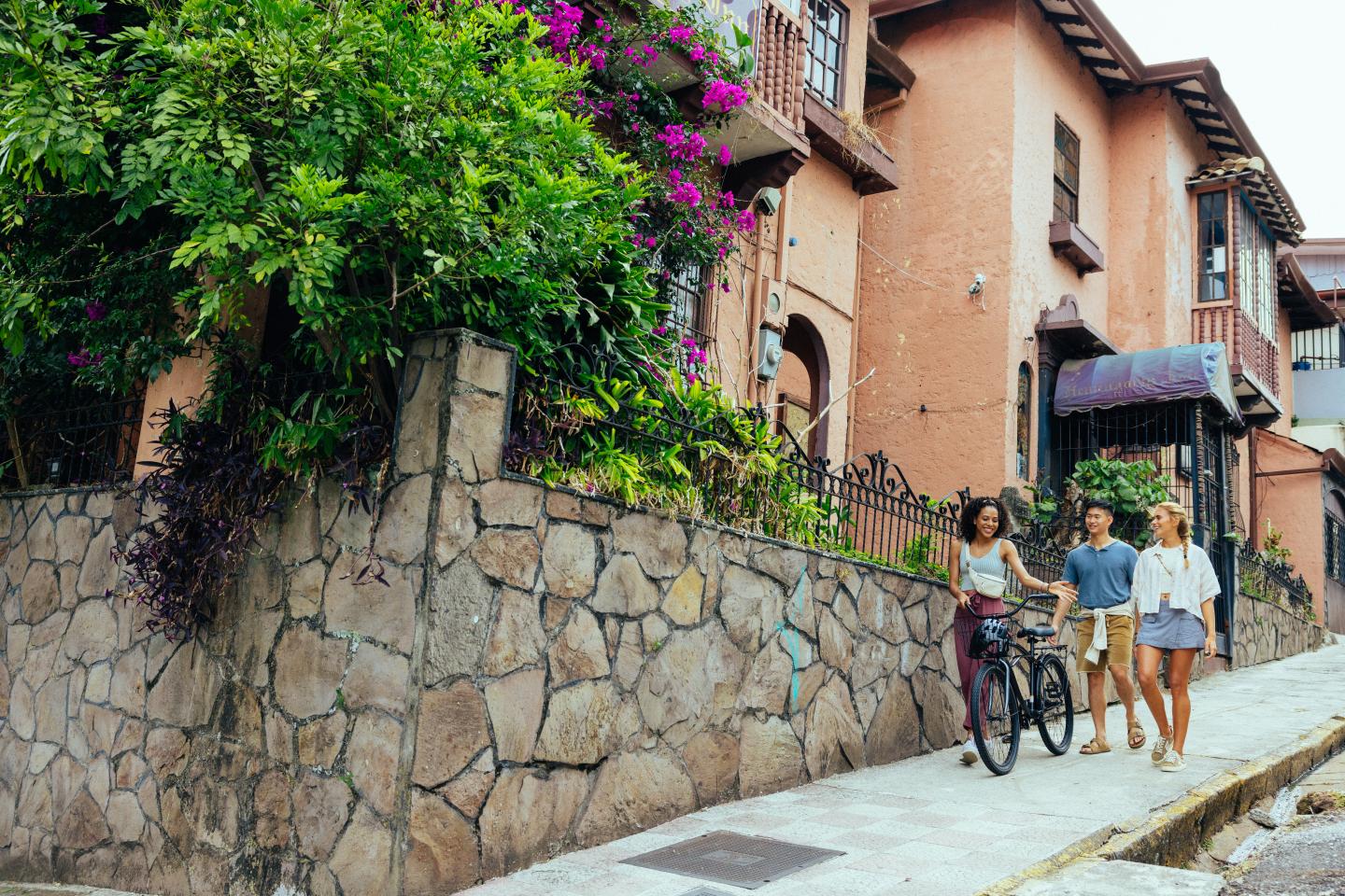 amigos paseando por un barrio con una bicicleta