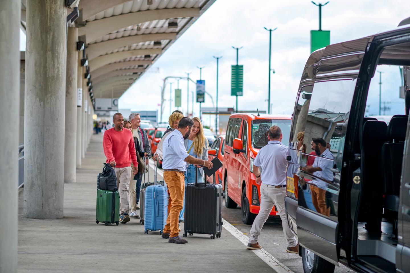 Hombre ayudando a una familia con las maletas en el aeropuerto.