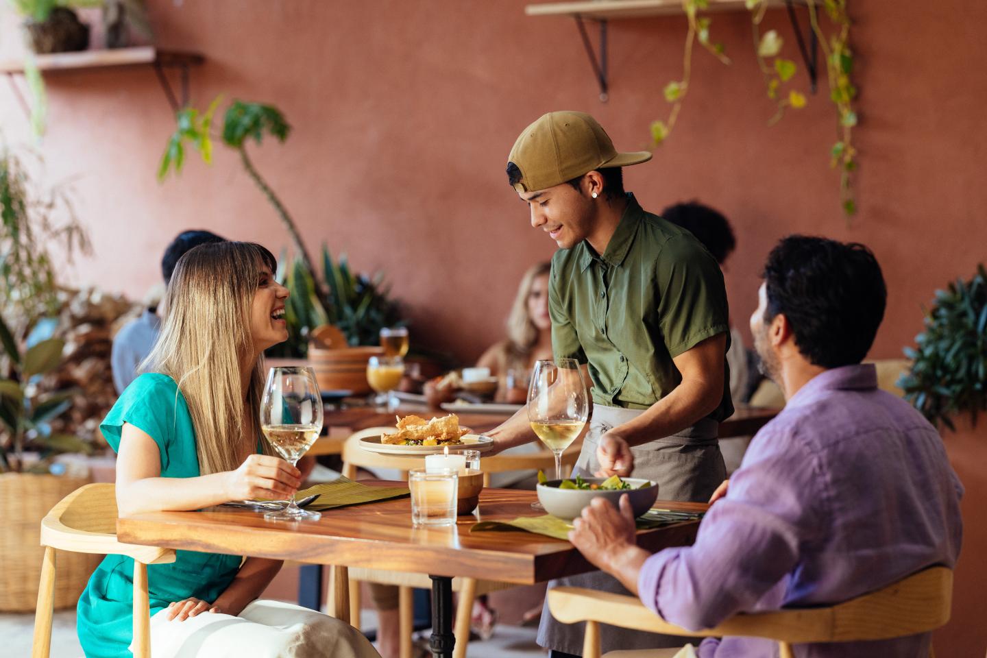 Pareja en una cafetería a la que le sirven la comida.